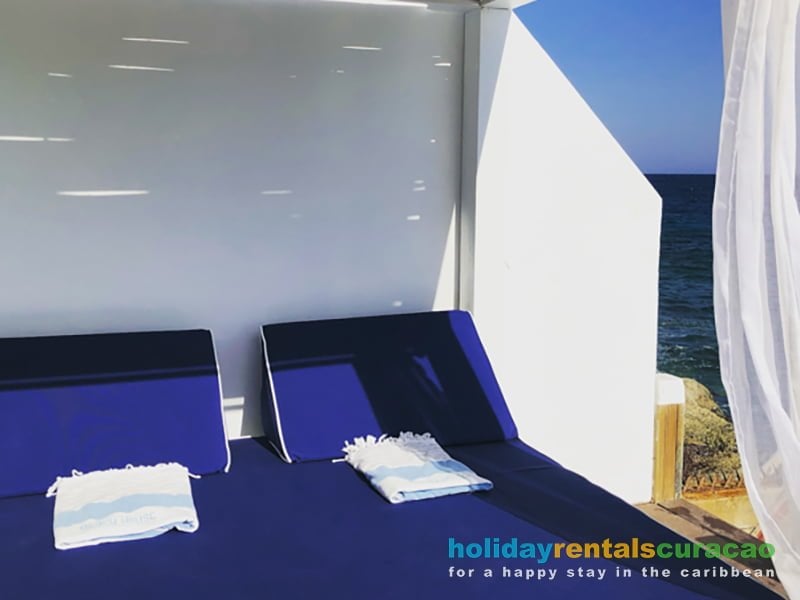 Comfortabele en luxe ligbedden met uitzicht op zee.
