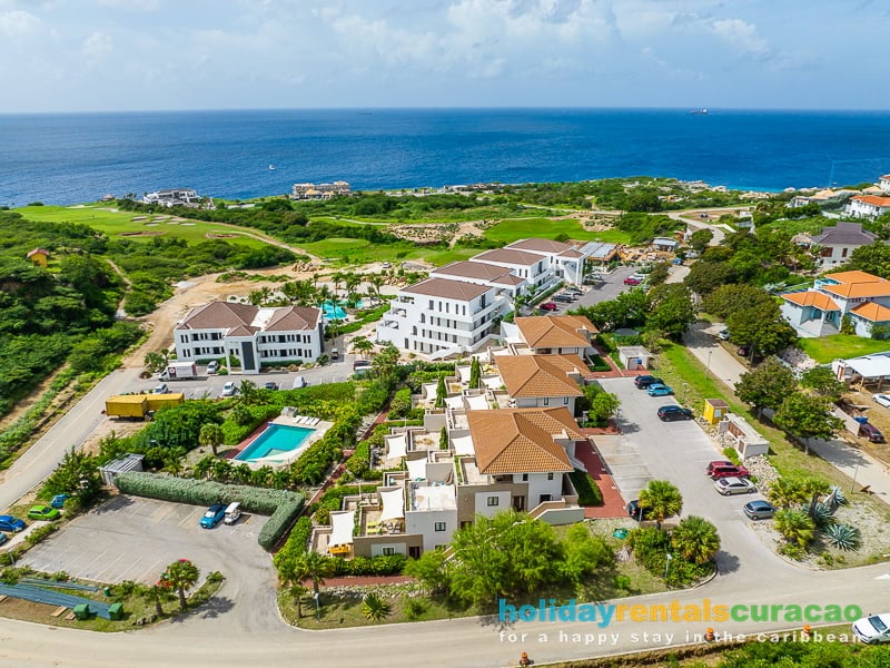 Luchtfoto van greenview en the reef appartementen met in de verte de zee