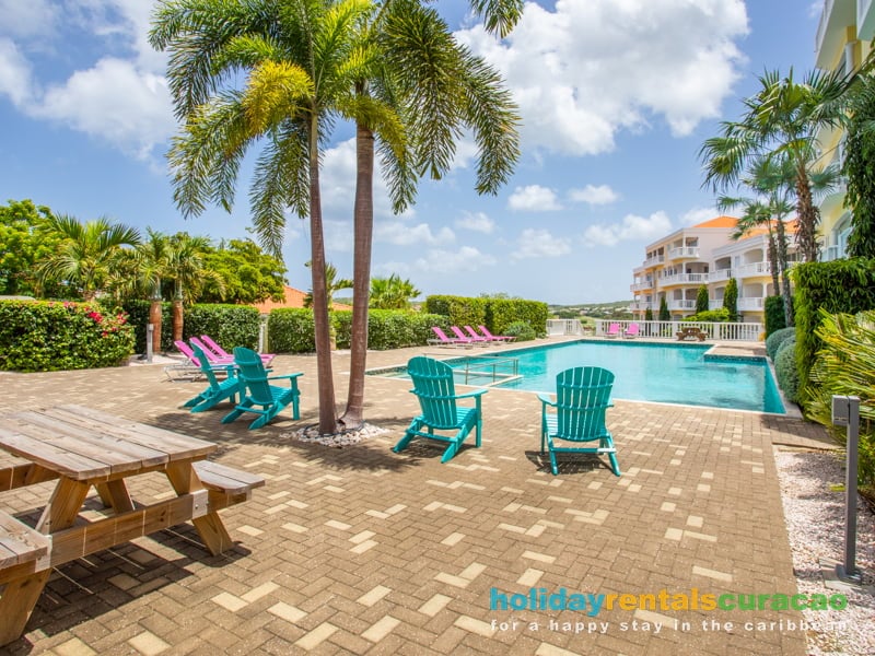 Zwembad met gekleurde (lig)stoelen ophet blue bay golf and beach resort